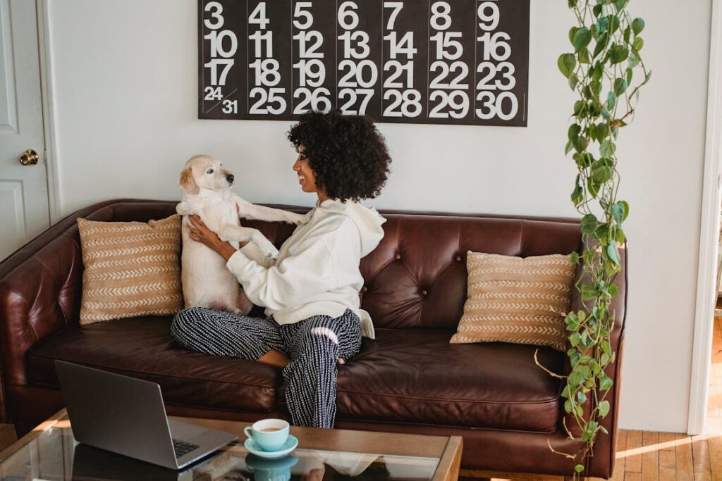 woman with her dog on a brown couch with tan pillows